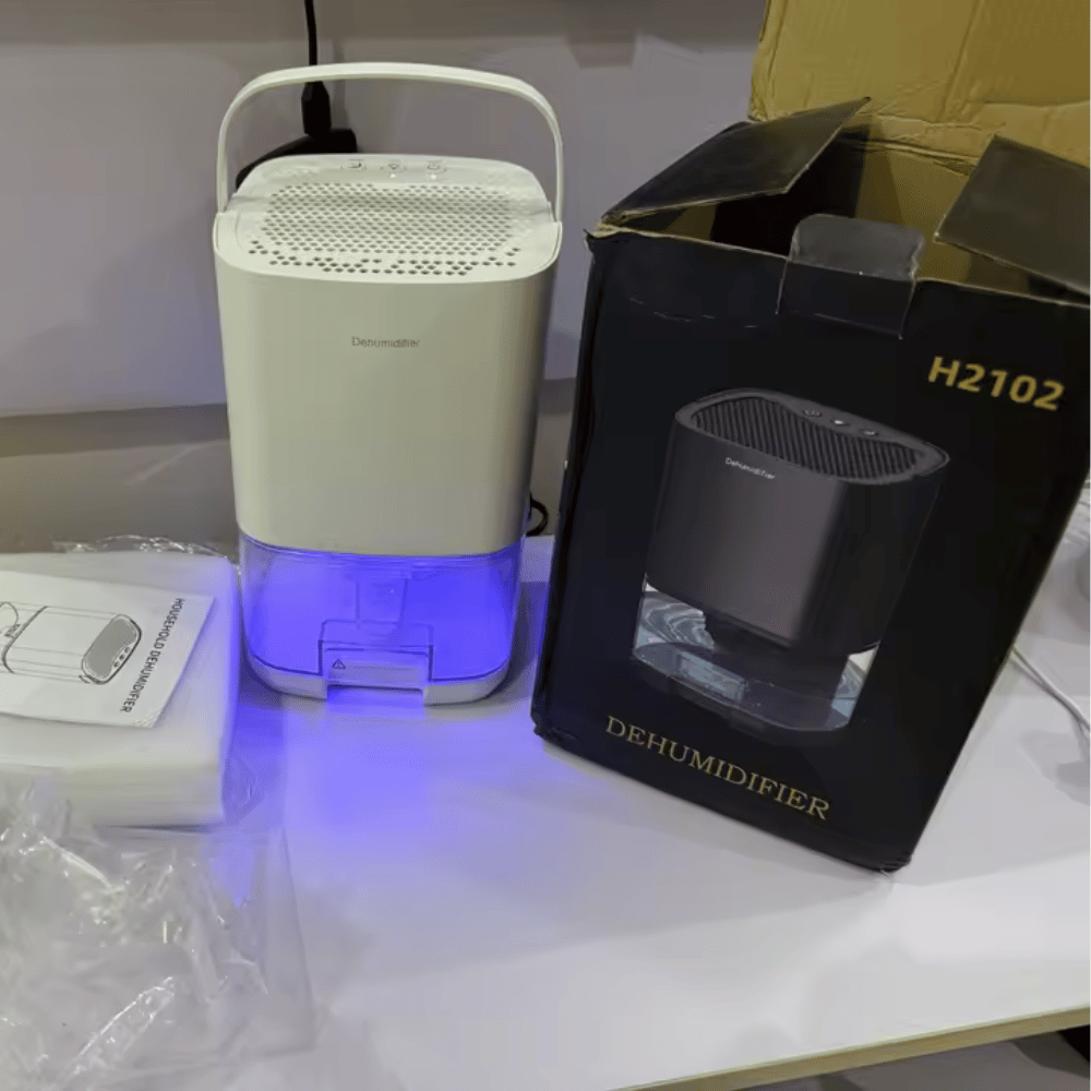 Portable air dehumidifier on a table with packaging box and manual.