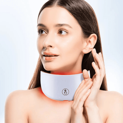 Woman wearing a neck massager with a plain background